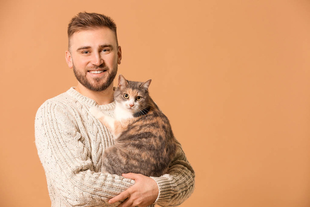 Man with cute cat on color background - Фото, изображение