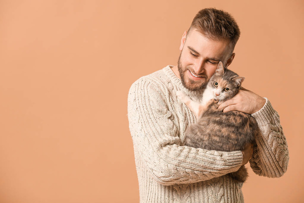 Man with cute cat on color background - Φωτογραφία, εικόνα