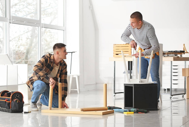 Handymen monteren meubels in werkplaats - Foto, afbeelding