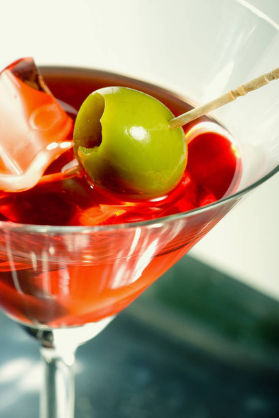 Martini glass with olive and ice cube - Foto, imagen