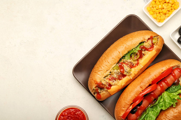 Samenstelling met lekkere hotdogs op lichte achtergrond - Foto, afbeelding