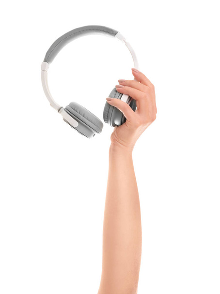 Mão com fones de ouvido modernos no fundo branco
 - Foto, Imagem