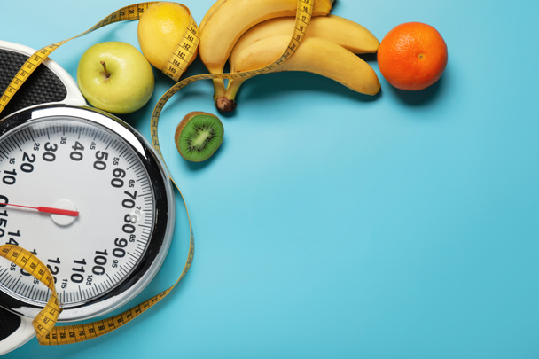 Different healthy food with measuring tape and scales on color background. Diet concept - Photo, Image