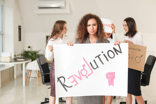 Young women with poster in office. Concept of feminism - 写真・画像