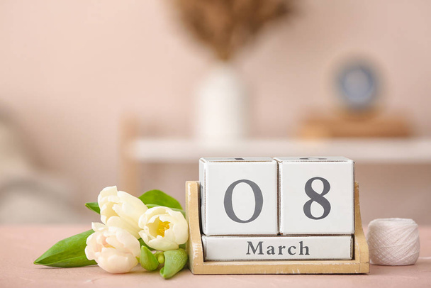 Ημερολόγιο με ημερομηνία της Παγκόσμιας Ημέρας της Γυναίκας και λουλούδια στο τραπέζι στο δωμάτιο - Φωτογραφία, εικόνα