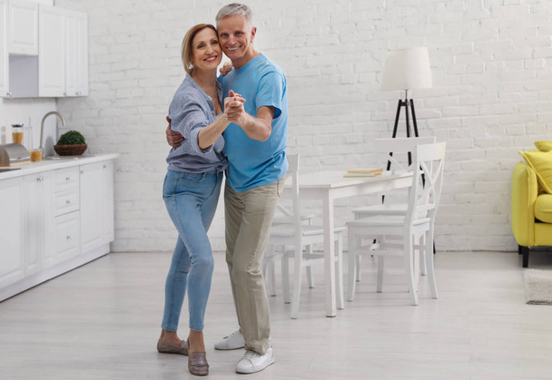 Happy senior couple dancing together in kitchen - Fotoğraf, Görsel