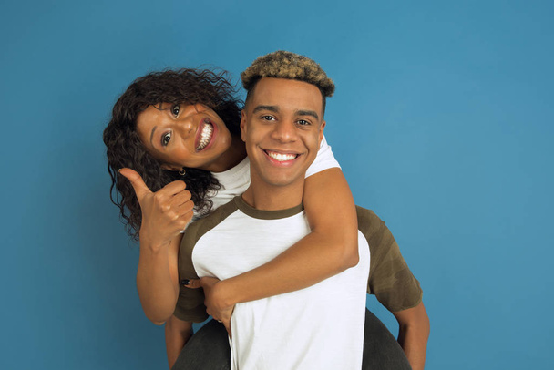 Young emotional african-american man and woman on blue background - Photo, image
