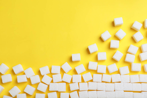Refined sugar cubes on yellow background, top view. Space for te - Fotó, kép