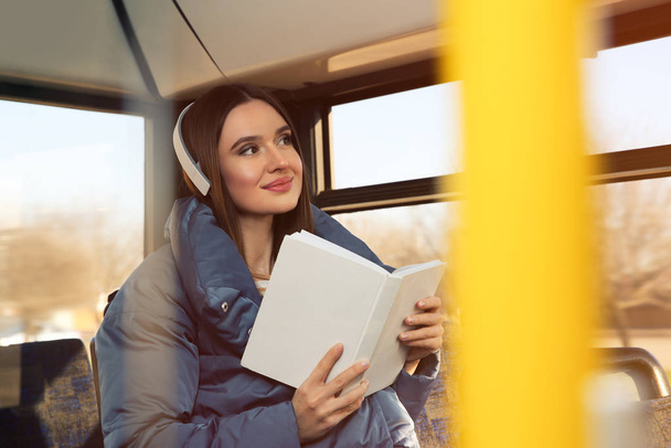 Woman listening to audiobook in trolley bus - Zdjęcie, obraz