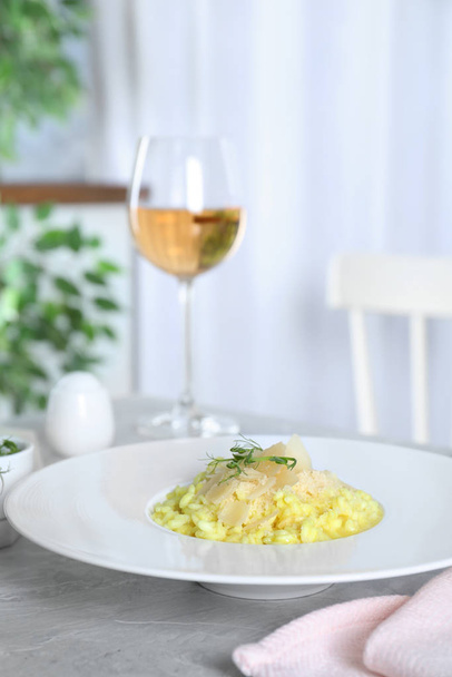 Delicious risotto with cheese on grey marble table indoors - Foto, afbeelding
