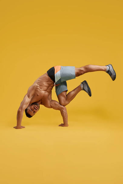 Athletic young man doing handstand exercise - Photo, Image