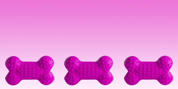 Kleurrijk rubber hondenbot geïsoleerd op witte achtergrond, puppy hondenspeelgoed nagebootst botten om te ontspannen met kauwen, site banner - Foto, afbeelding