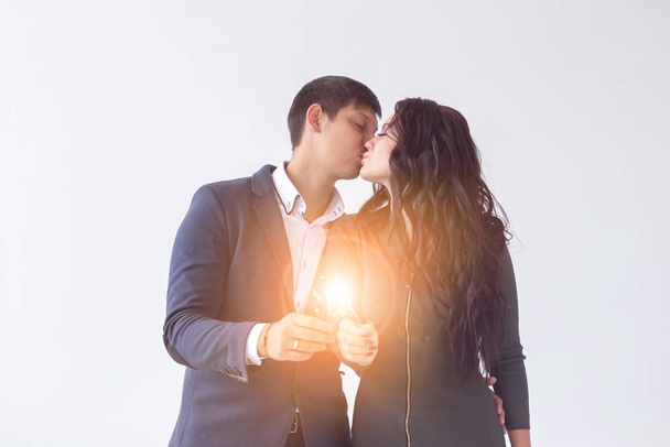 Conceito de dia e data dos namorados - Casal com sparklers no fundo branco
 - Foto, Imagem