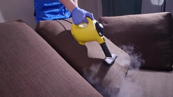 Bútortisztító koncepció. A kanapé tisztítása antibakteriális gőztisztítóval - Felvétel, videó