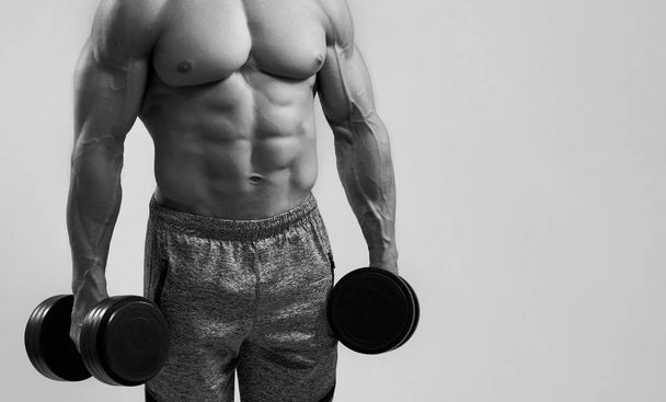 muskulöser kräftiger Bodybuilder mit Kurzhanteln - Foto, Bild