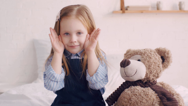 Niedliche Kind versteckt sich von Teddybär auf Bett - Filmmaterial, Video