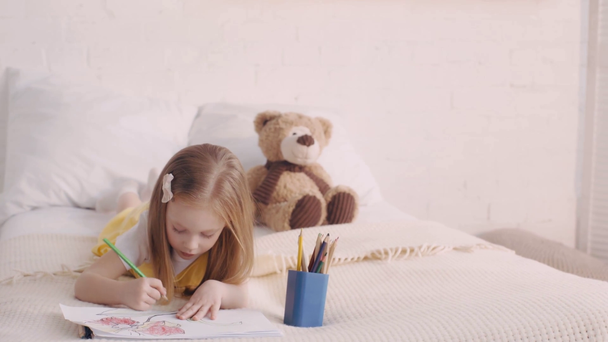 Детский рисунок с красочными карандашами от плюшевого мишки на кровати
 - Кадры, видео
