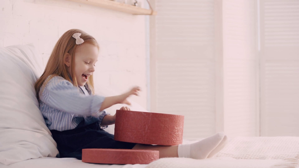 Niño sorprendido con caja de regalo en la cama
 - Metraje, vídeo