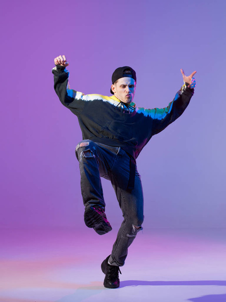 Breakdancing young man in hoodie and baseball cap. Dance school poster. Copy space. Battle competition announcement. - Photo, Image