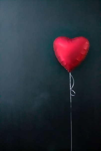Red air balloons in the shape of a heart on a black background. valentines day, love. - Fotó, kép