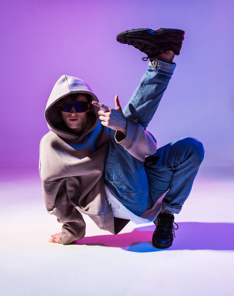 Breakdancing young man in hoodie with hair styling. Dance school poster. Copy space. Battle competition announcement. - Foto, afbeelding