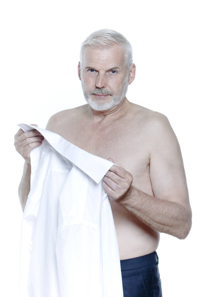 old senior man with gray hair undress his shirt - 写真・画像