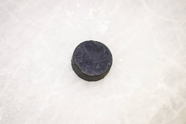 Disco di gomma di hocikey di ghiaccio nero situato sulla pista di pattinaggio arena. Ghiaccio
 - Foto, immagini
