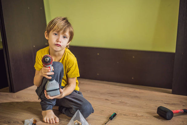 Boy assembling furniture. Boy helping his dad at home. Happy Family concept - Valokuva, kuva