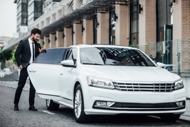 Handsome young businessman near new white car, selective focus - Photo, image