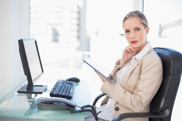 Thoughtful blonde businesswoman using tablet - Фото, зображення
