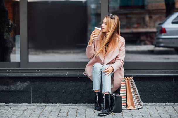 Beautiful young blonde woman with shopping bags, selective focus - Valokuva, kuva