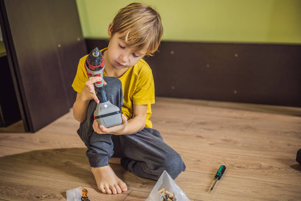 Boy assembling furniture. Boy helping his dad at home. Happy Family concept - Fotoğraf, Görsel
