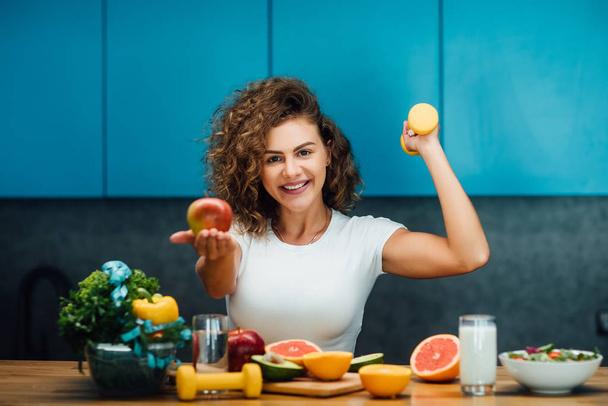Piękna kobieta ze zdrowym zielonym jedzeniem w nowoczesnej kuchni  - Zdjęcie, obraz