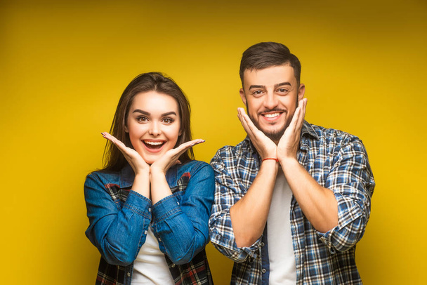 cheerful young couple against yellow background - Photo, image
