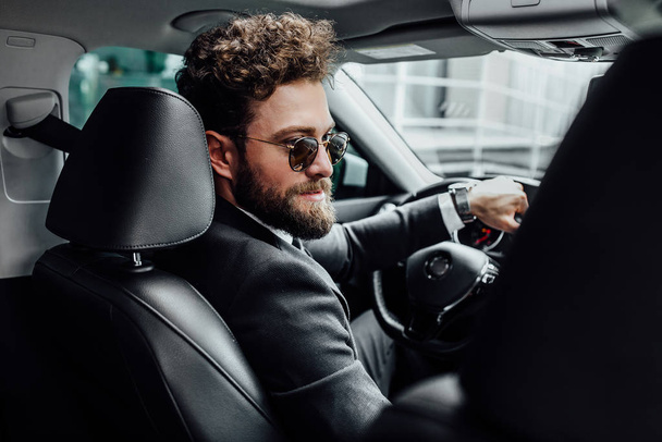 Handsome young businessman driving car, selective focus - Foto, afbeelding