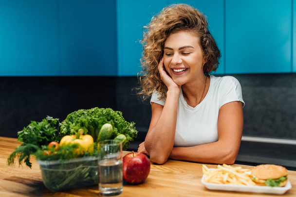 Beautiful woman with healthy green food at modern kitchen  - Photo, Image
