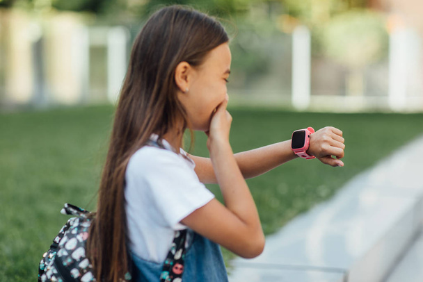 girl wearing jeans dress and using smartwatch  - Foto, Imagem