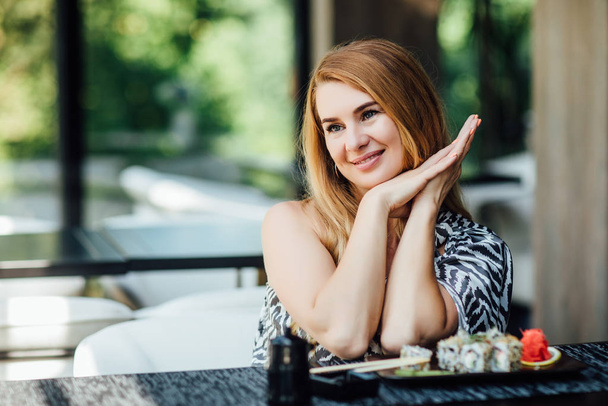 Portrait of pretty blonde woman on summer terrace, selective focus - Фото, зображення