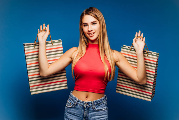 Pretty woman with shopping bags posing on colorful background - Fotoğraf, Görsel