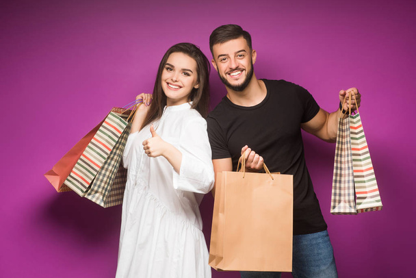 Happy couple posing with shopping bags - Фото, зображення
