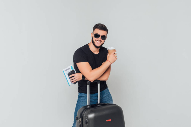 Portrait of young businessman, tourist with passport and suitcase and phone isolated on white background  - Foto, Imagem