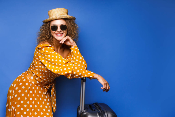 Surprised woman in vintage dress stay on background holding suitcase  - Photo, image