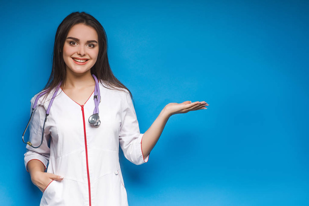 Young gorgeous brunette doctor posing on colorful background - Fotó, kép
