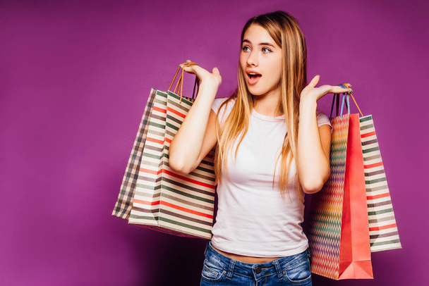 Pretty woman with shopping bags posing on colorful background - Fotografie, Obrázek