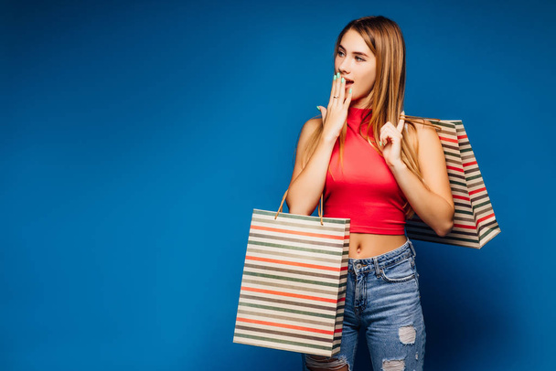 Pretty woman with shopping bags posing on colorful background - Photo, Image