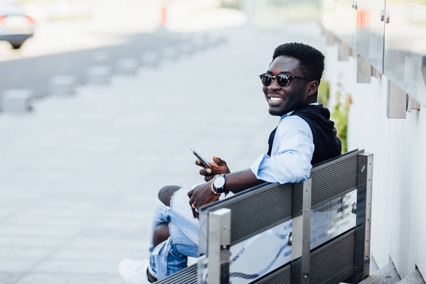 Young man holding coffee and using phone  - Fotó, kép