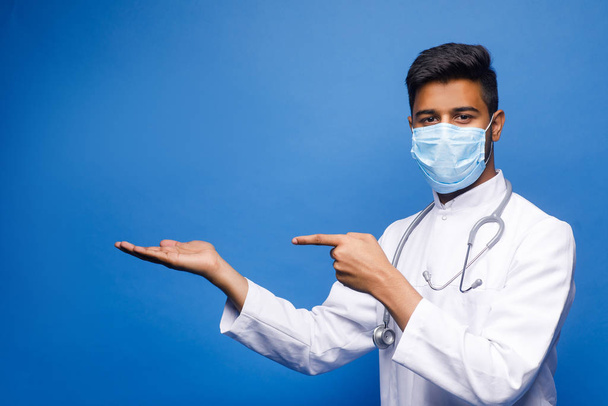 indian male doctor in white coat on blue background - Φωτογραφία, εικόνα