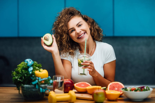 現代のキッチンで健康的な緑の食べ物を持つ美しい女性  - 写真・画像