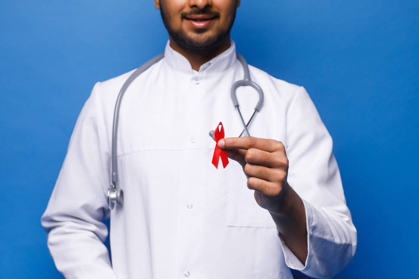 indian male doctor in white coat on blue background - Valokuva, kuva