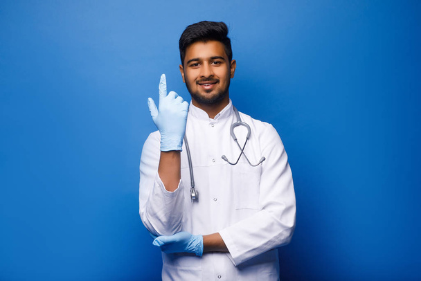 indian male doctor in white coat on blue background - Foto, Bild